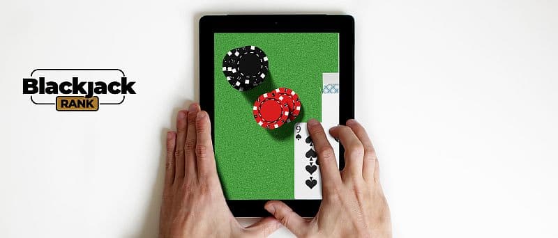 Tablet in Handen mit Blackjack auf dem Bildschirm